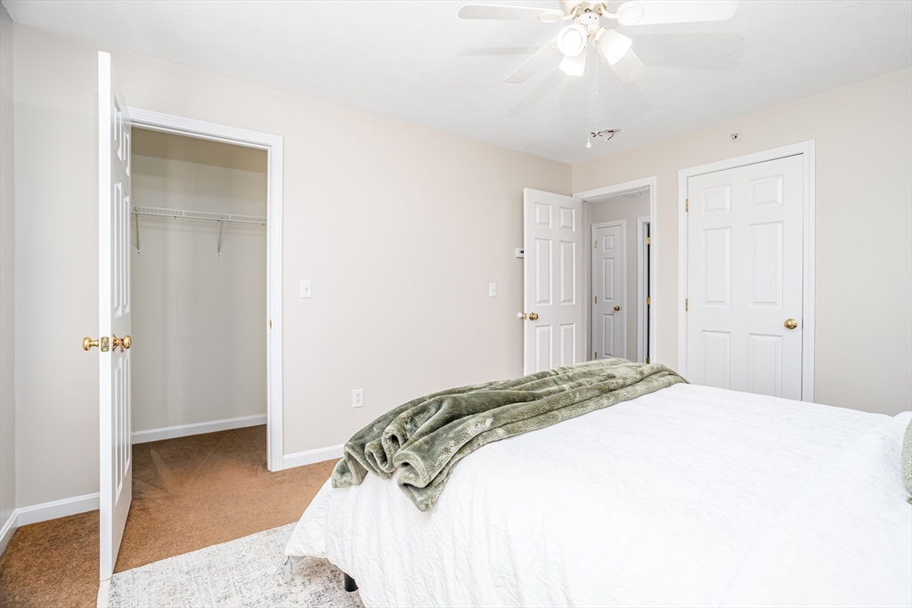 104 Lake Street, Unit 104 Gardner, MA 01440 - Photo 15 of 30 a bedroom with a bed and a chandelier
