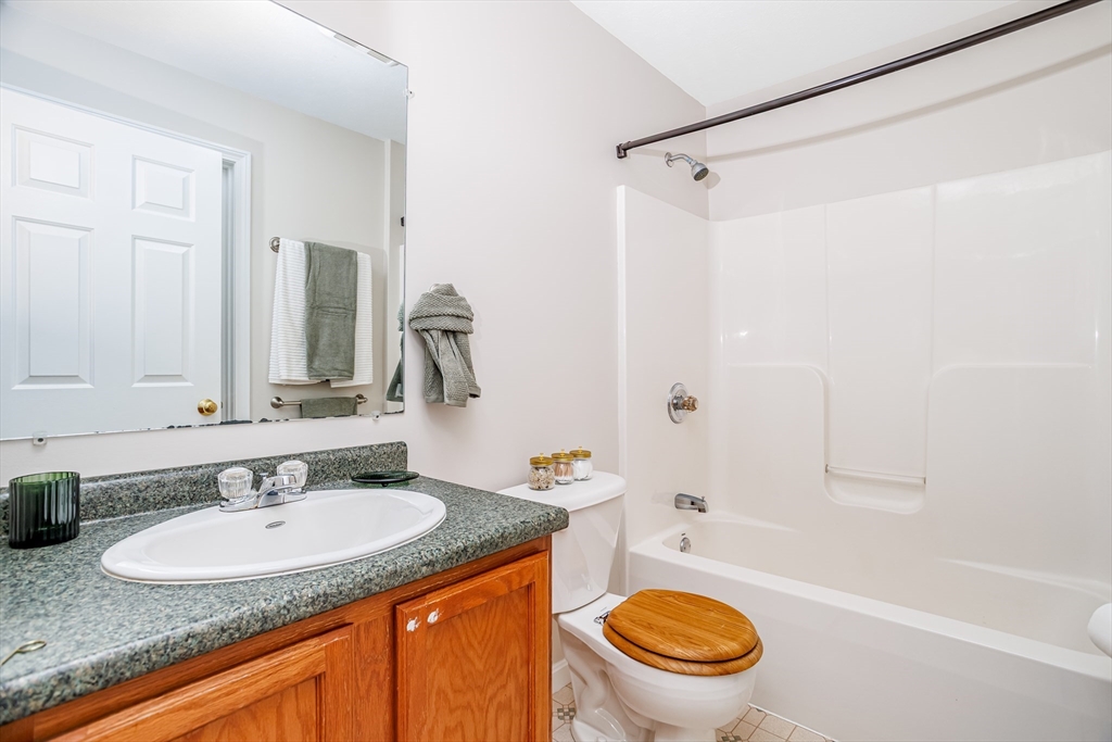 104 Lake Street, Unit 104 Gardner, MA 01440 - Photo 17 of 30 a bathroom with a granite countertop toilet sink and mirror