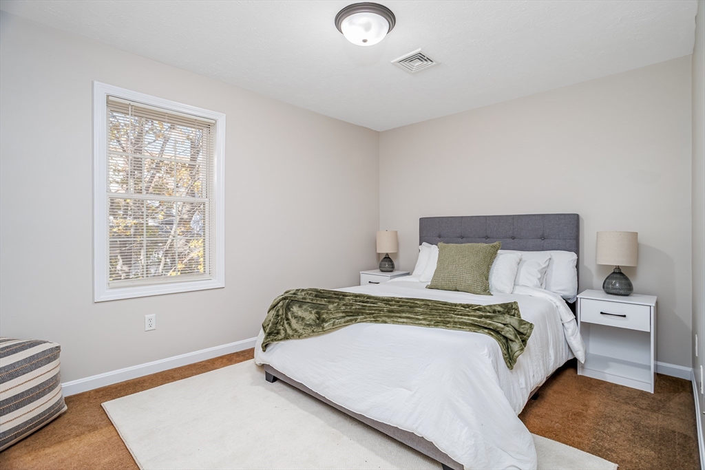 104 Lake Street, Unit 104 Gardner, MA 01440 - Photo 19 of 30 a bed sitting in a bedroom next to a window