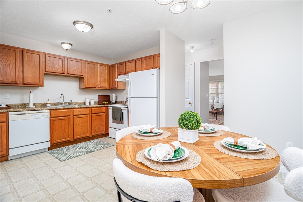 104 Lake Street, Unit 104 Gardner, MA 01440 - Photo 8 of 30 a kitchen with stainless steel appliances kitchen island granite countertop a dining table and chairs