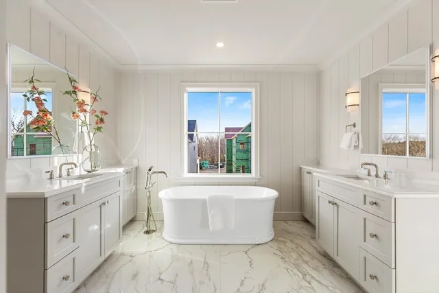 a bathroom with a tub sink and mirror