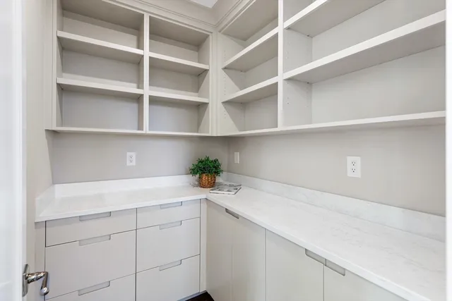 a view of a white house with large windows next to a road