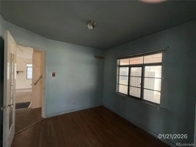 an empty room with wooden floor and closet