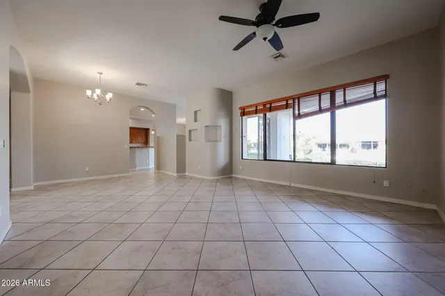 a view of a livingroom with a chandelier fan and windows