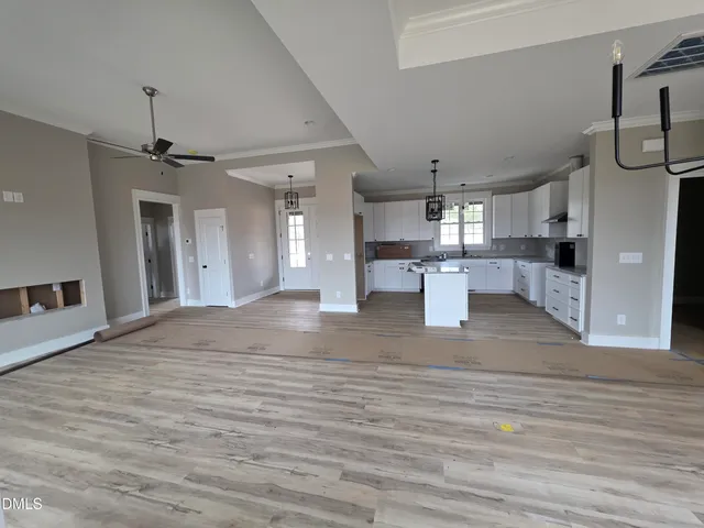 a view of a kitchen with a sink and dishwasher with wooden floor