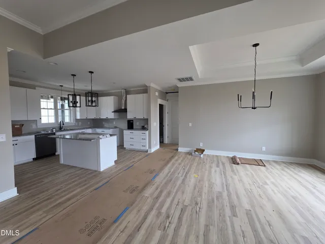 a large kitchen with stainless steel appliances a large counter top a sink and a refrigerator