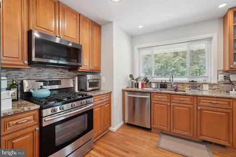 a kitchen with stainless steel appliances a stove microwave and sink