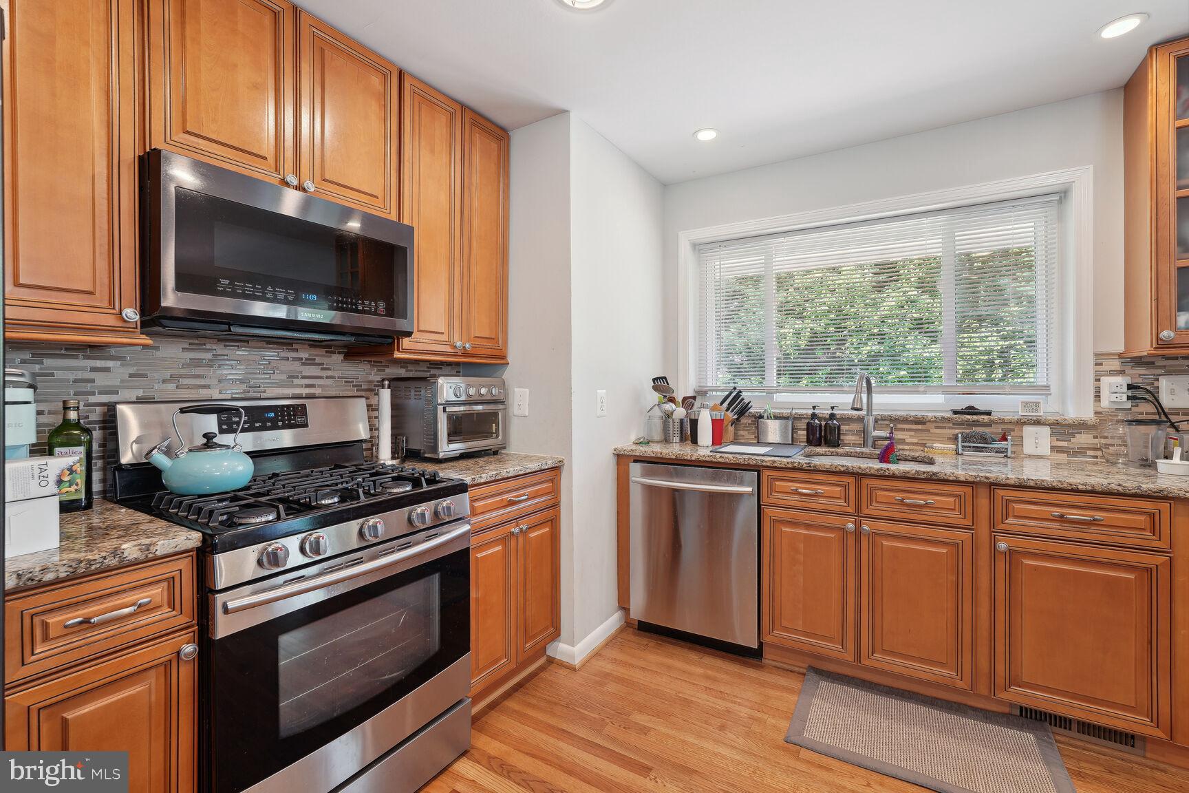 7011 Hector Road McLean, VA 22101 - Photo 3 of 20 a kitchen with stainless steel appliances a stove microwave and sink