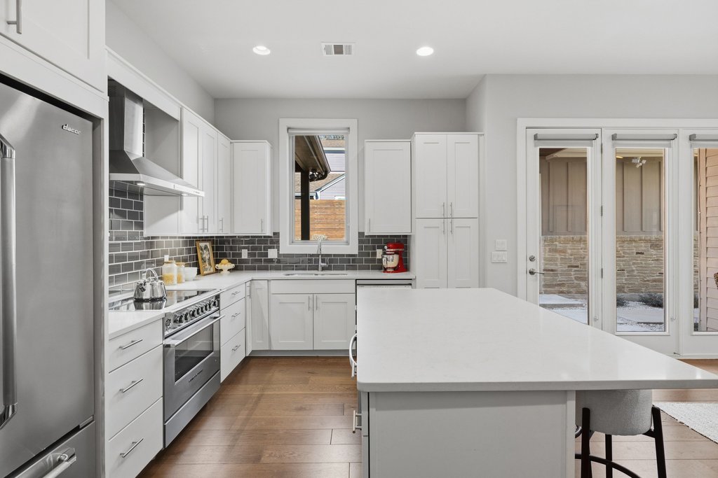 a kitchen with stainless steel appliances white cabinets and a refrigerator