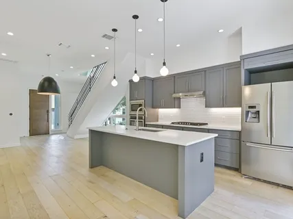 a kitchen with stainless steel appliances granite countertop a sink a stove and a refrigerator