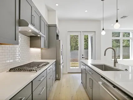 a kitchen that has a sink cabinets and a stove