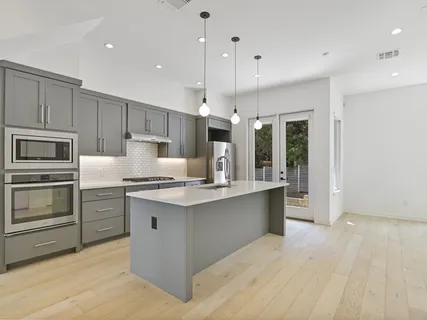 a kitchen with kitchen island a sink stainless steel appliances and cabinets