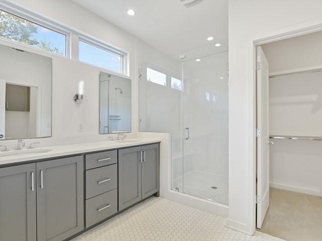 2506 Sutherland Street Austin, TX 78746 - Photo 9 of 17 a spacious bathroom with a shower a sink and a mirror
