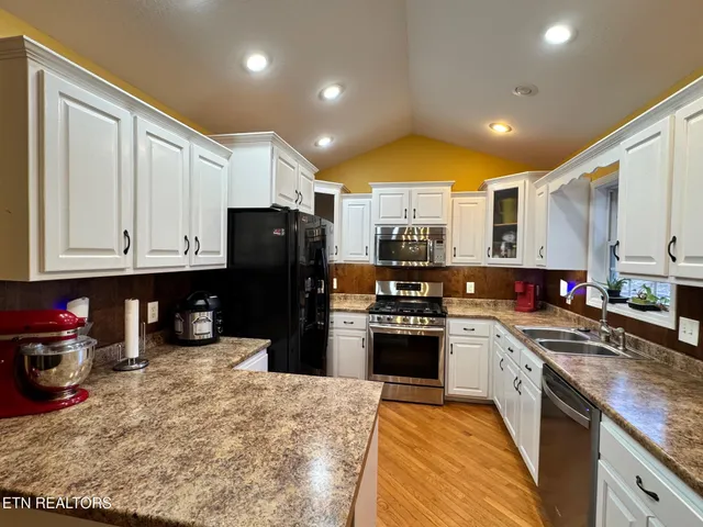 a kitchen with kitchen island granite countertop wooden cabinets and stainless steel appliances