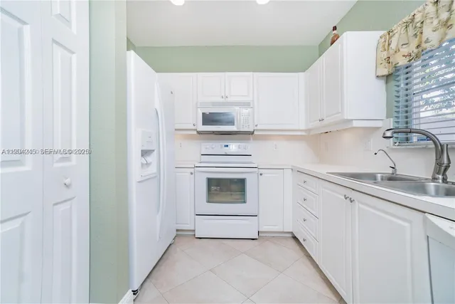 a kitchen with white cabinets and a sink