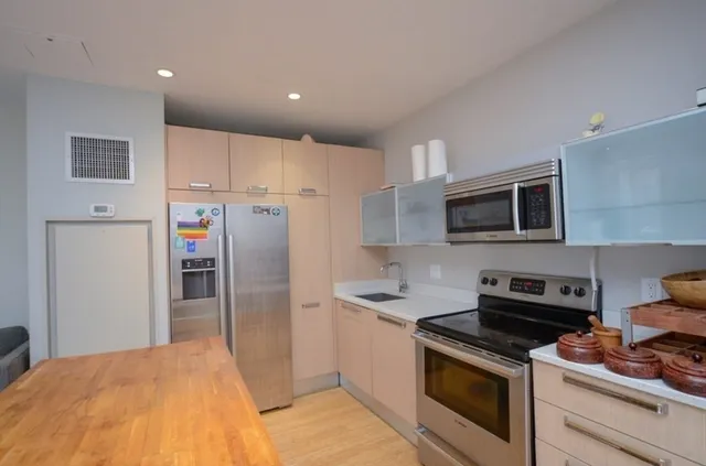 a kitchen with stainless steel appliances granite countertop a stove a refrigerator and a microwave