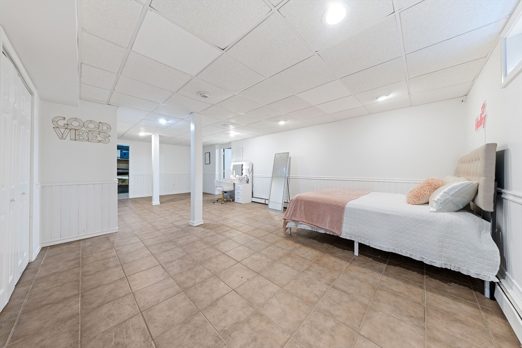 63 Farm Hill Road North Attleboro, MA 02760 - Photo 34 of 42 a spacious bedroom with a bed a couch and chandelier