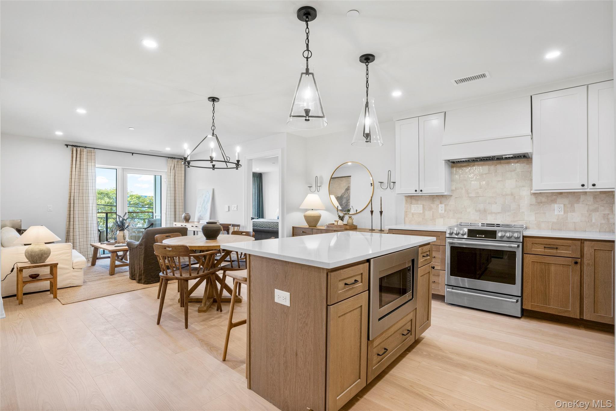 25 North Riverside Avenue, Unit 211 Croton-on-Hudson, NY 10520 - Photo 2 of 27 a kitchen with kitchen island a stove a sink a oven a dining table and chairs