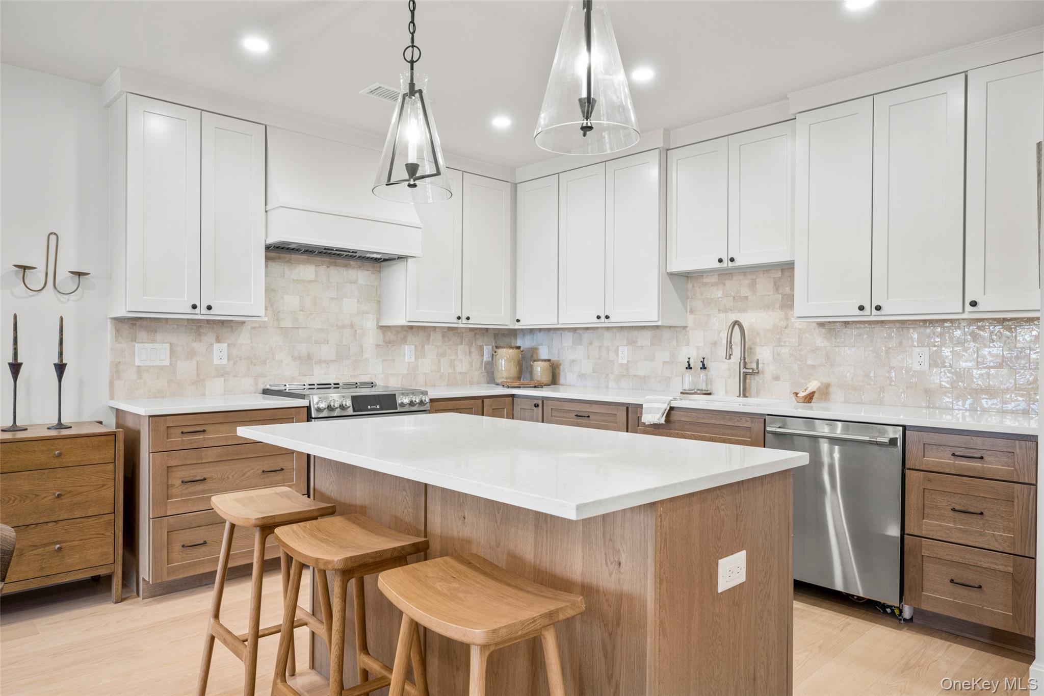 25 North Riverside Avenue, Unit 211 Croton-on-Hudson, NY 10520 - Photo 3 of 27 a kitchen with kitchen island granite countertop a sink a center island and cabinets