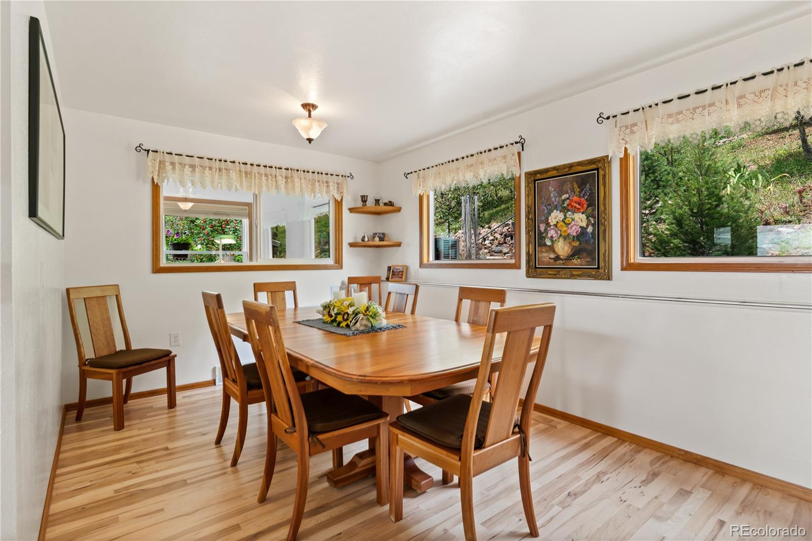 64 Highland Road Palmer Lake, CO 80133 - Photo 6 of 17 a view of a dining room with furniture a potted plant and wooden floor