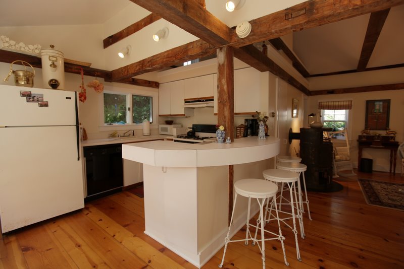 29 Glendale Road Stockbridge, MA 01262 - Photo 9 of 23 a kitchen with stainless steel appliances a microwave a stove a refrigerator a dining table and chairs with wooden floor