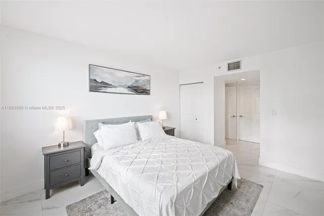 a spacious bedroom with a bed and a dresser