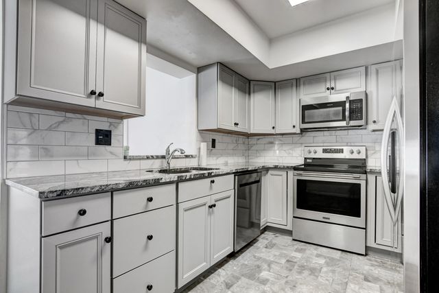 a kitchen with stainless steel appliances granite countertop a stove a microwave and cabinets