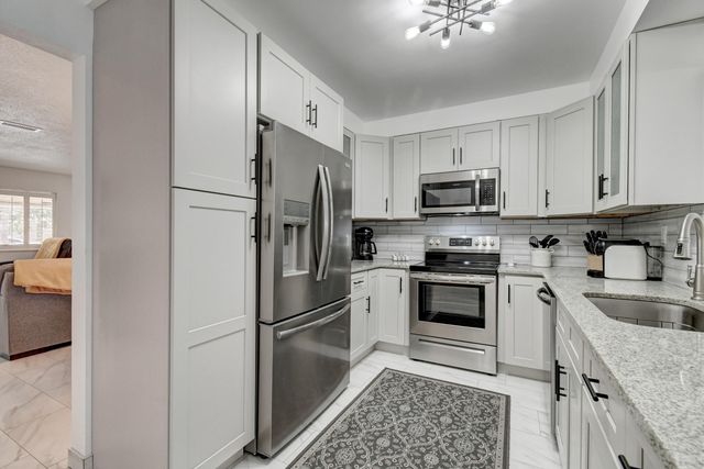 a kitchen with stainless steel appliances granite countertop a sink stove and cabinets