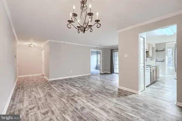 a view of a hallway with wooden floor and a chandelier