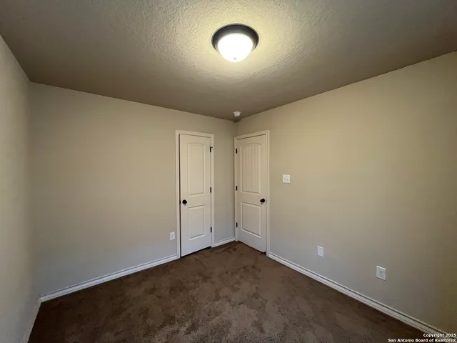 an empty room with a ceiling fan and a window