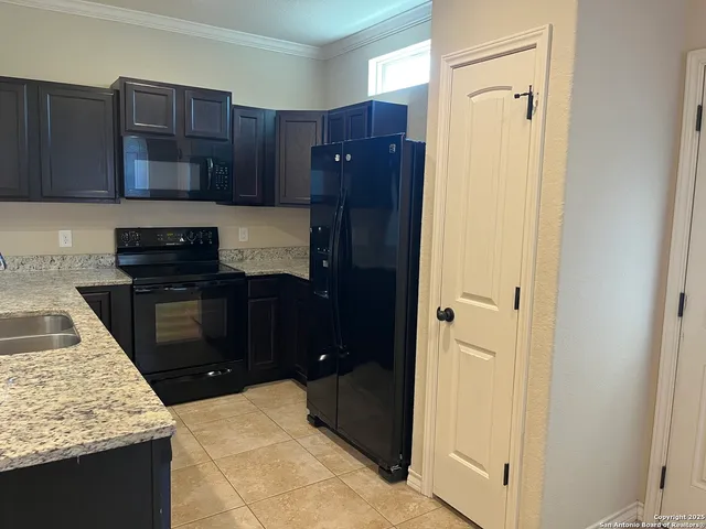 a kitchen with granite countertop a refrigerator and a stove