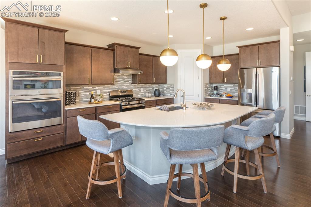 12516 Stone Valley Drive Peyton, CO 80831 - Photo 11 of 44 a kitchen with a dining table chairs stainless steel appliances and cabinets