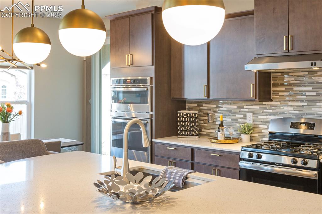 12516 Stone Valley Drive Peyton, CO 80831 - Photo 12 of 44 a kitchen with stainless steel appliances granite countertop a stove a sink and a dining table