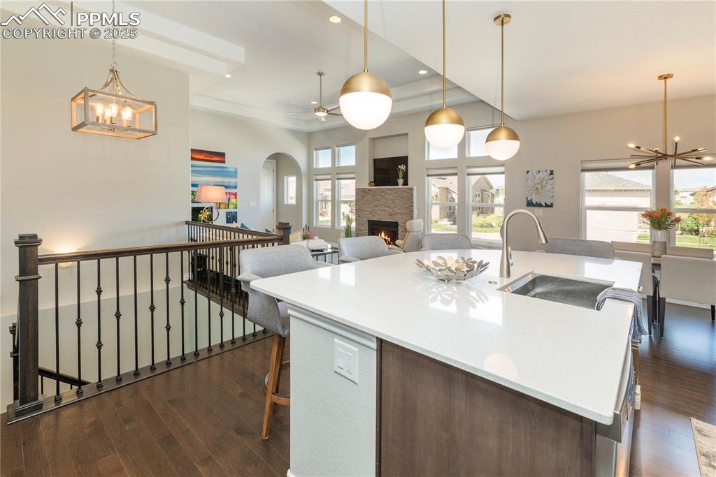12516 Stone Valley Drive Peyton, CO 80831 - Photo 20 of 44 a dining room with wooden floor a chandelier a wooden table and chairs