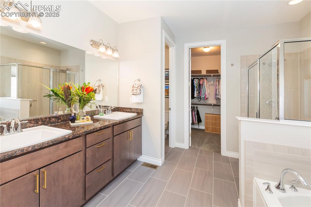 12516 Stone Valley Drive Peyton, CO 80831 - Photo 23 of 44 a bathroom with a double vanity sink and a mirror