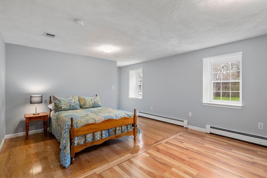 27 Middle Road Sudbury, MA 01776 - Photo 23 of 33 a bedroom with a bed lamp and a window