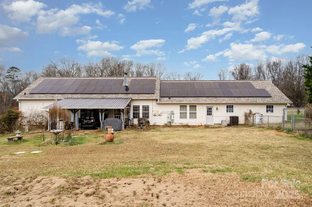 a view of a big house with wooden fence