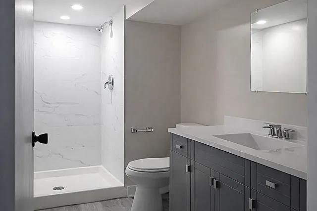 a bathroom with a sink a toilet and shower