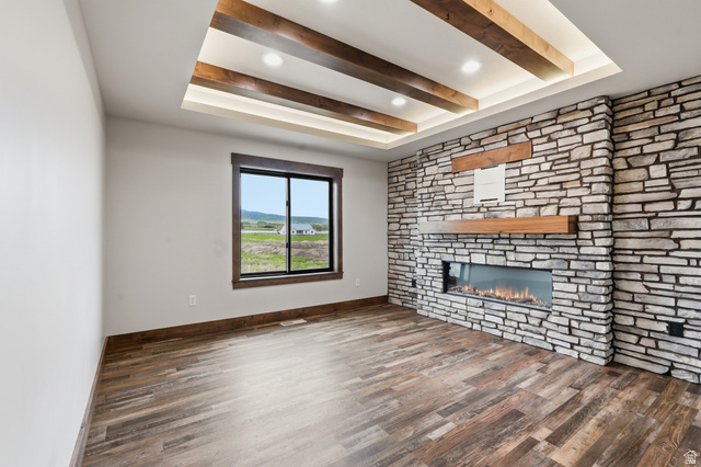 2970 North Mahogany Vly Road Logan, UT 84341 - Photo 30 of 39 Unfurnished living room with a tray ceiling, dark wood-type flooring, a fireplace, and recessed lighting