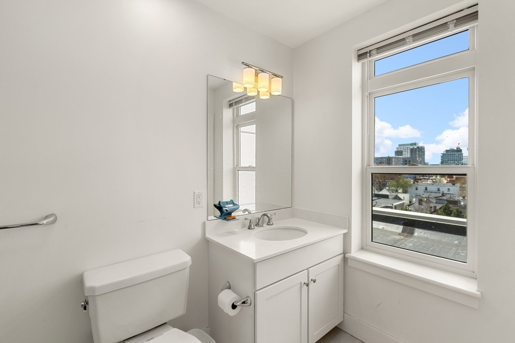20 Penniman Road, Unit P3 Boston, MA 02134 - Photo 16 of 22 a bathroom with a sink a toilet and a mirror