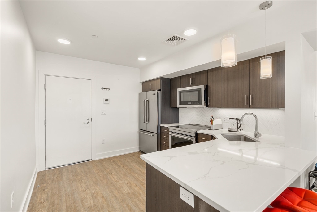 20 Penniman Road, Unit P3 Boston, MA 02134 - Photo 3 of 22 a kitchen with stainless steel appliances granite countertop a sink stove and refrigerator
