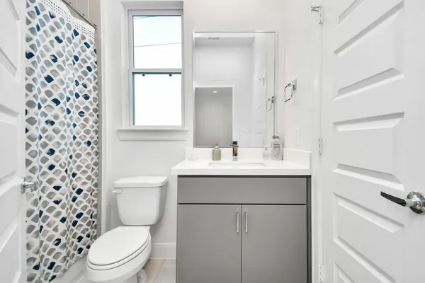 a bathroom with a sink a toilet and shower curtain