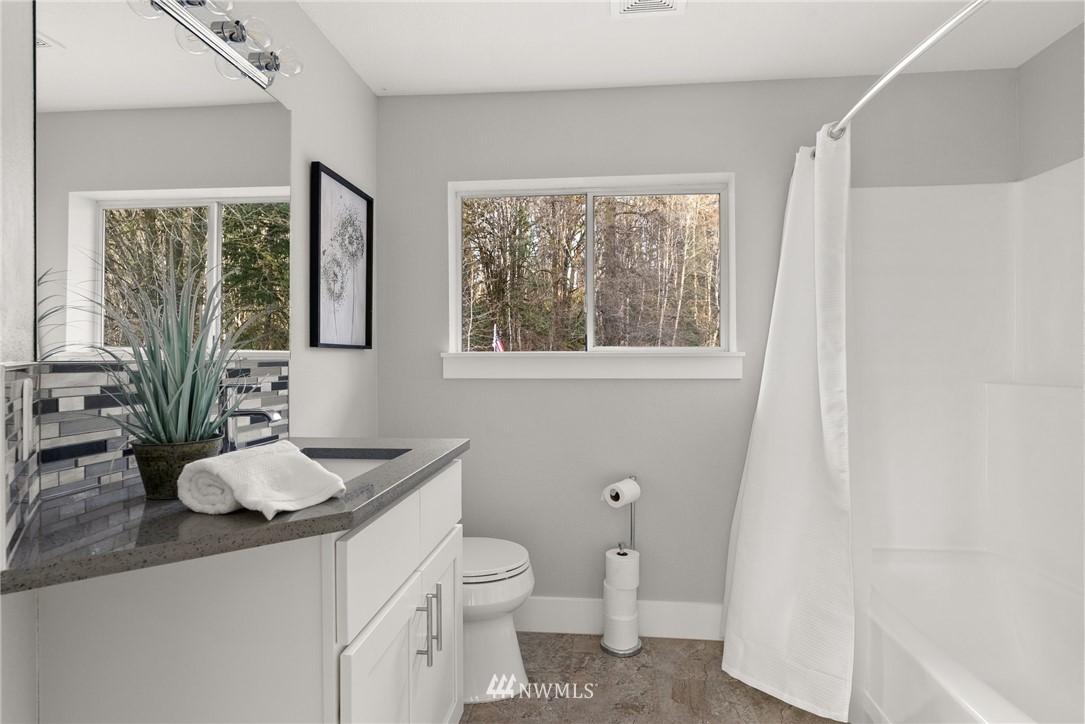 14126 Littlerock Road Southwest Rochester, WA 98579 - Photo 26 of 40 a bathroom with a granite countertop sink toilet and large mirror