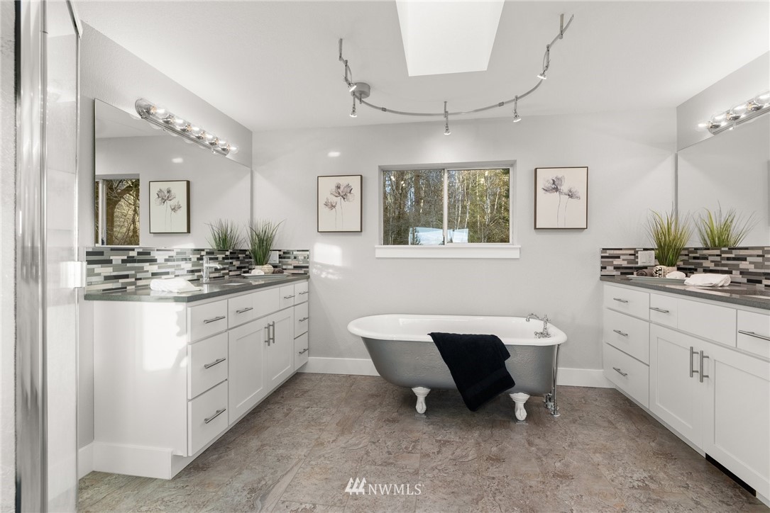 14126 Littlerock Road Southwest Rochester, WA 98579 - Photo 33 of 40 a spacious bathroom with a double vanity sink a mirror a bathtub and a toilet