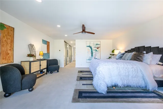 a bedroom with furniture and a ceiling fan