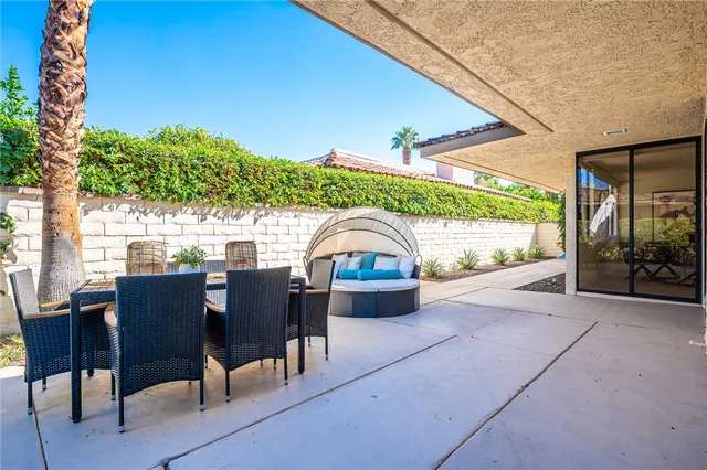 a view of a patio with a table and chairs under an umbrella