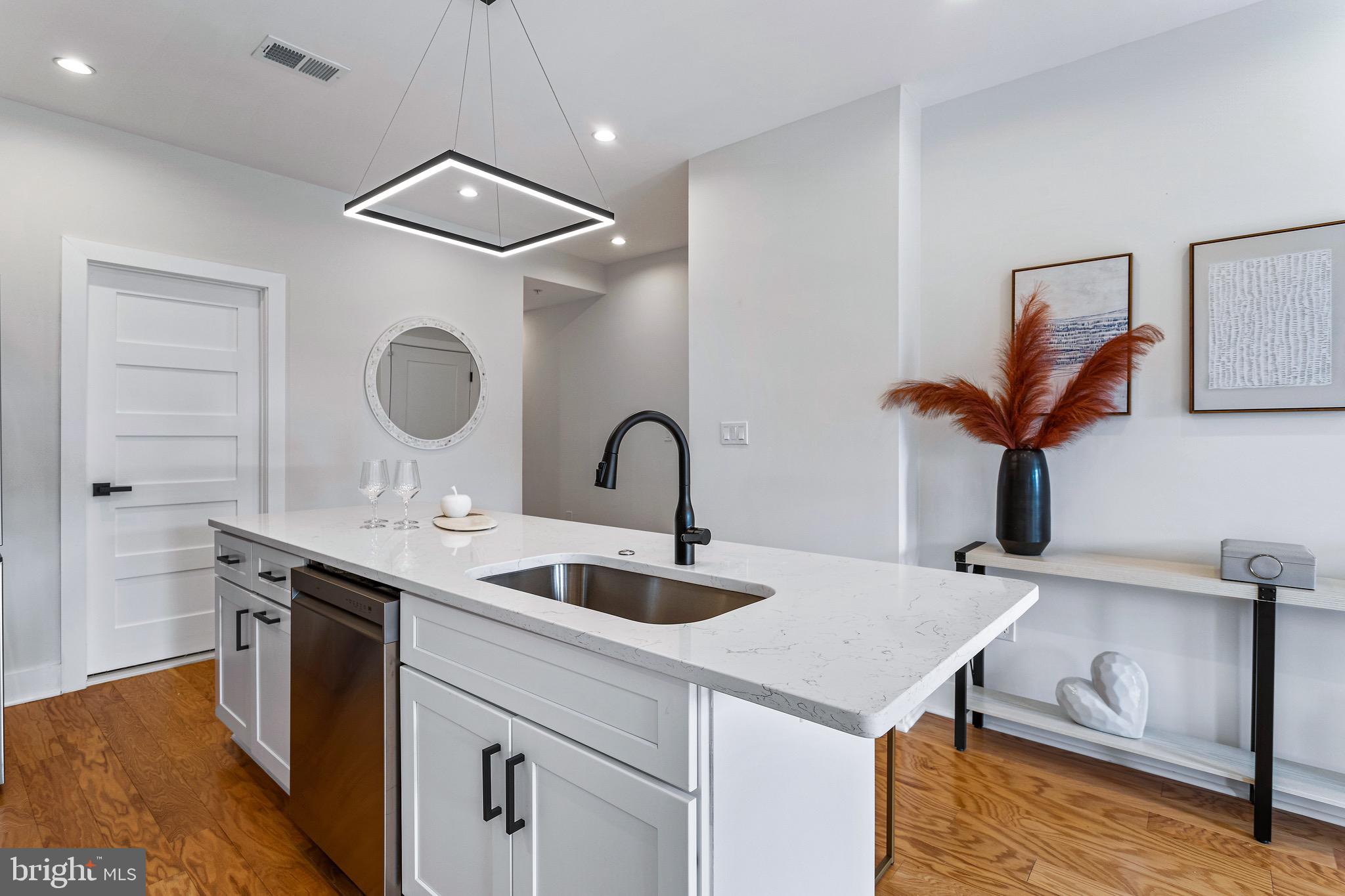 1118 Neal Street Northeast, Unit 2 Washington, DC 20002 - Photo 3 of 25 a kitchen with kitchen island a sink appliances and a counter top space