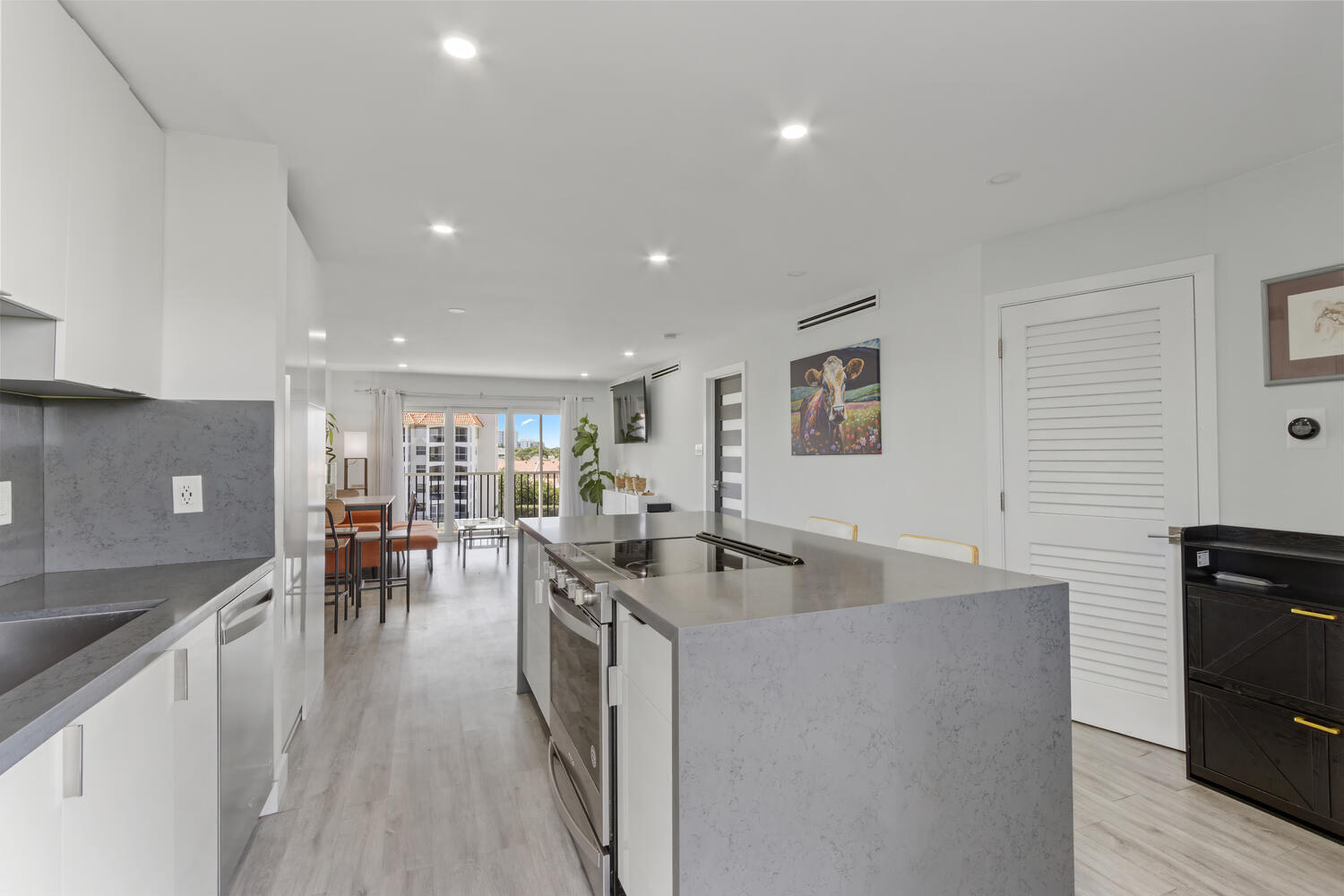 2871 North Ocean Boulevard, Unit V443 Boca Raton, FL 33431 - Photo 12 of 49 a kitchen with stainless steel appliances granite countertop a stove top oven a sink a dining table and chairs with wooden floor