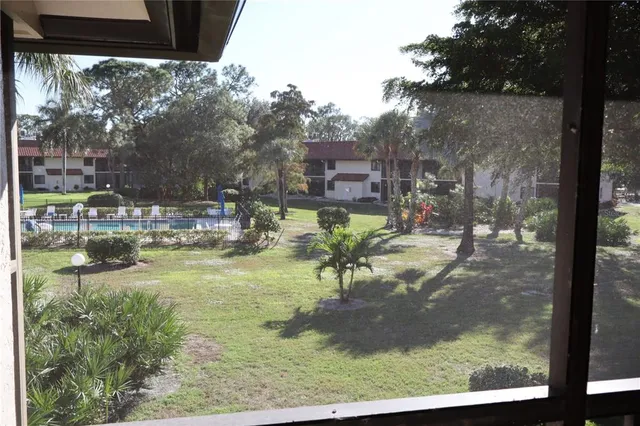 a view of a swimming pool with a bench and chairs