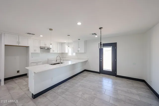 a large kitchen with kitchen island a sink stainless steel appliances and cabinets